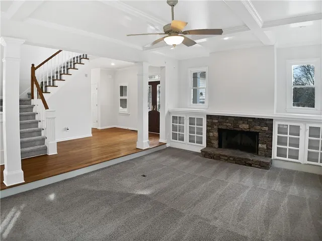 an empty room with windows and fireplace