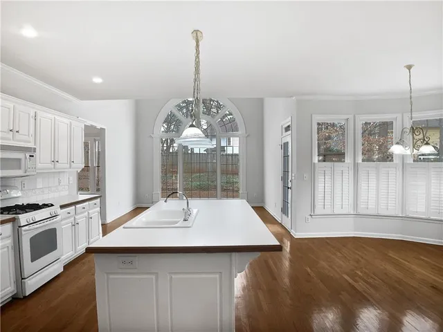 a kitchen with a sink chandelier and stove
