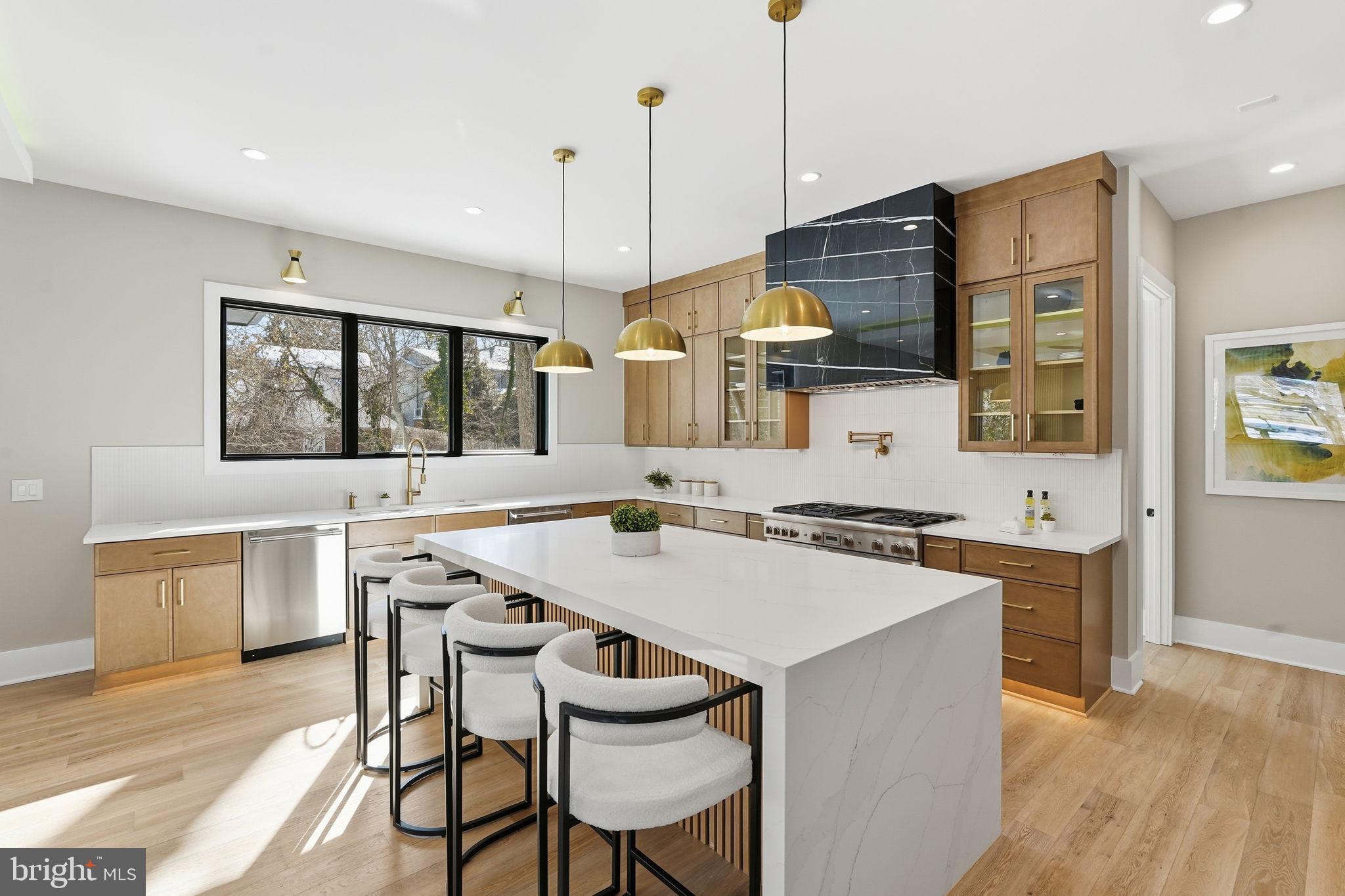 2202 Grayson Place Falls Church, VA 22043 - Photo 14 of 77 a kitchen with a stove a sink a kitchen island with a dining table and chairs