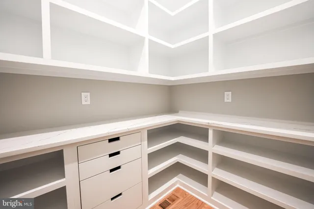a spacious bedroom with a large bed and a chandelier