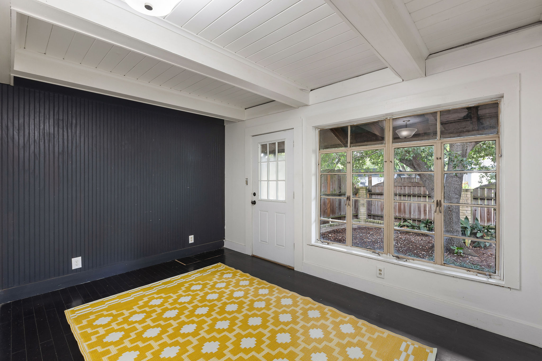 948 Maple Street Lockhart, TX 78644 - Photo 17 of 40 Exposed beams and beadboard ceiling create visual interest in this versatile room with backyard views.