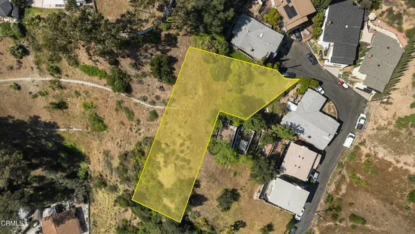 an aerial view of residential house with outdoor space and trees all around