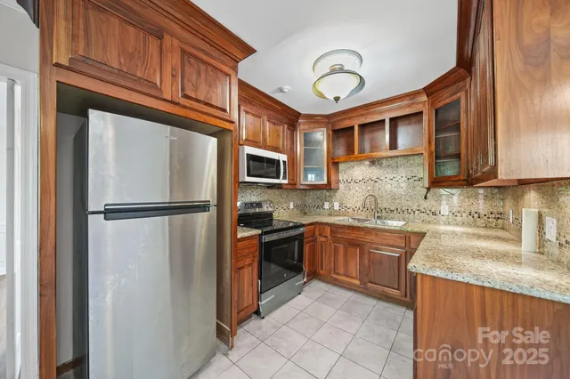 a kitchen with stainless steel appliances granite countertop a refrigerator and a sink