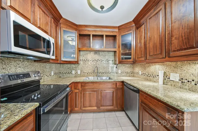 a kitchen with stainless steel appliances granite countertop a sink and a stove