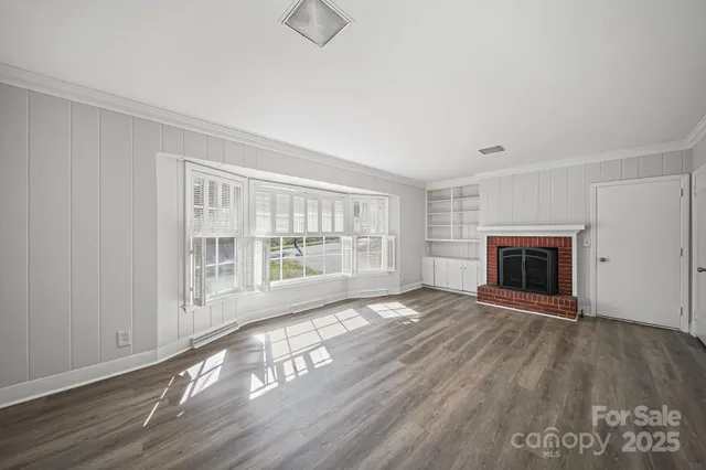 wooden floor fireplace and windows in an empty room