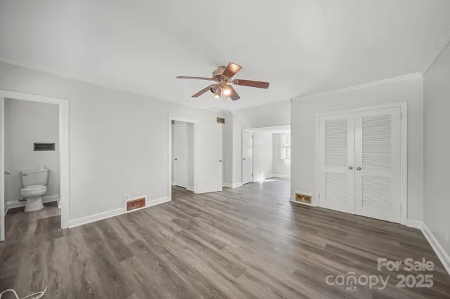 a view of a room with wooden floor and a ceiling fan