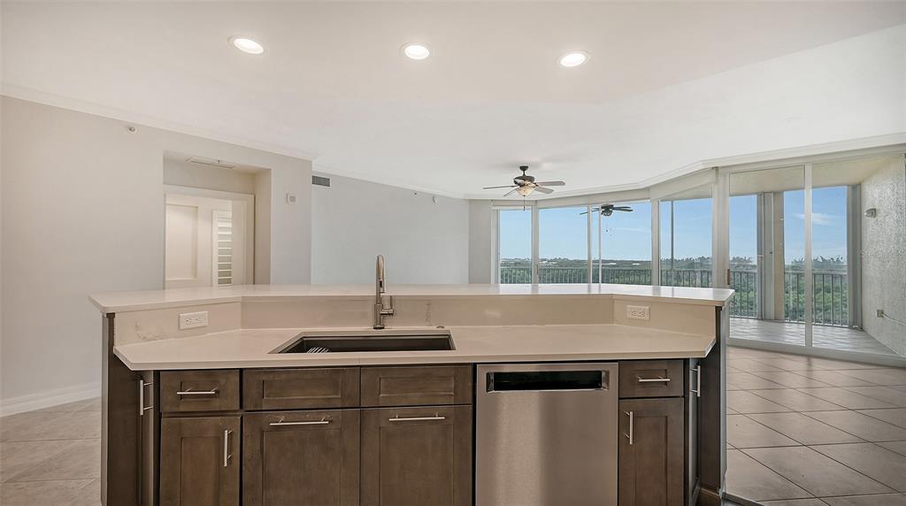 401 North Point Road, Unit 603 Osprey, FL 34229 - Photo 27 of 96 a kitchen with kitchen island granite countertop a sink a center island and cabinets