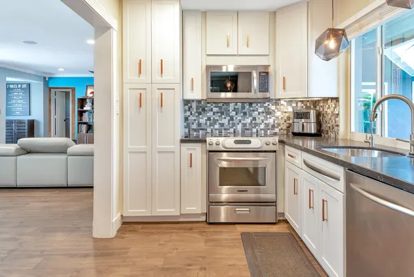 a kitchen with stainless steel appliances granite countertop a refrigerator and a stove top oven