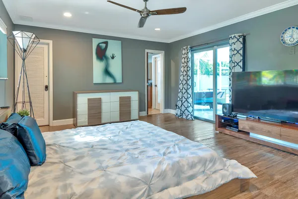 a bedroom with a bed and a large mirror with wooden floor