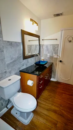 a bathroom with a granite countertop sink a toilet and a shower
