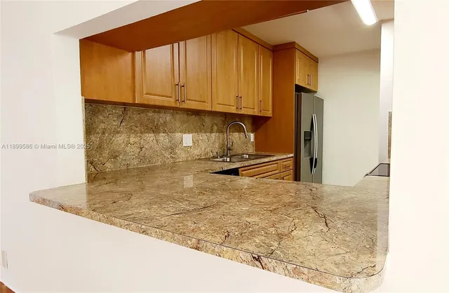 a view of kitchen island a sink a counter top space