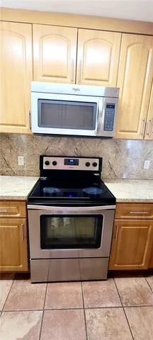 a stove top oven sitting inside of a kitchen