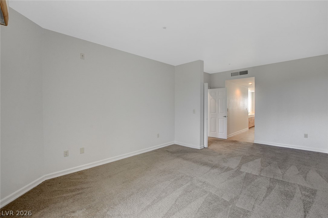230 East Flamingo Road, Unit 404 Las Vegas, NV 89169 - Photo 19 of 34 Plush carpeting anchors this versatile room opening to an adjacent hallway.