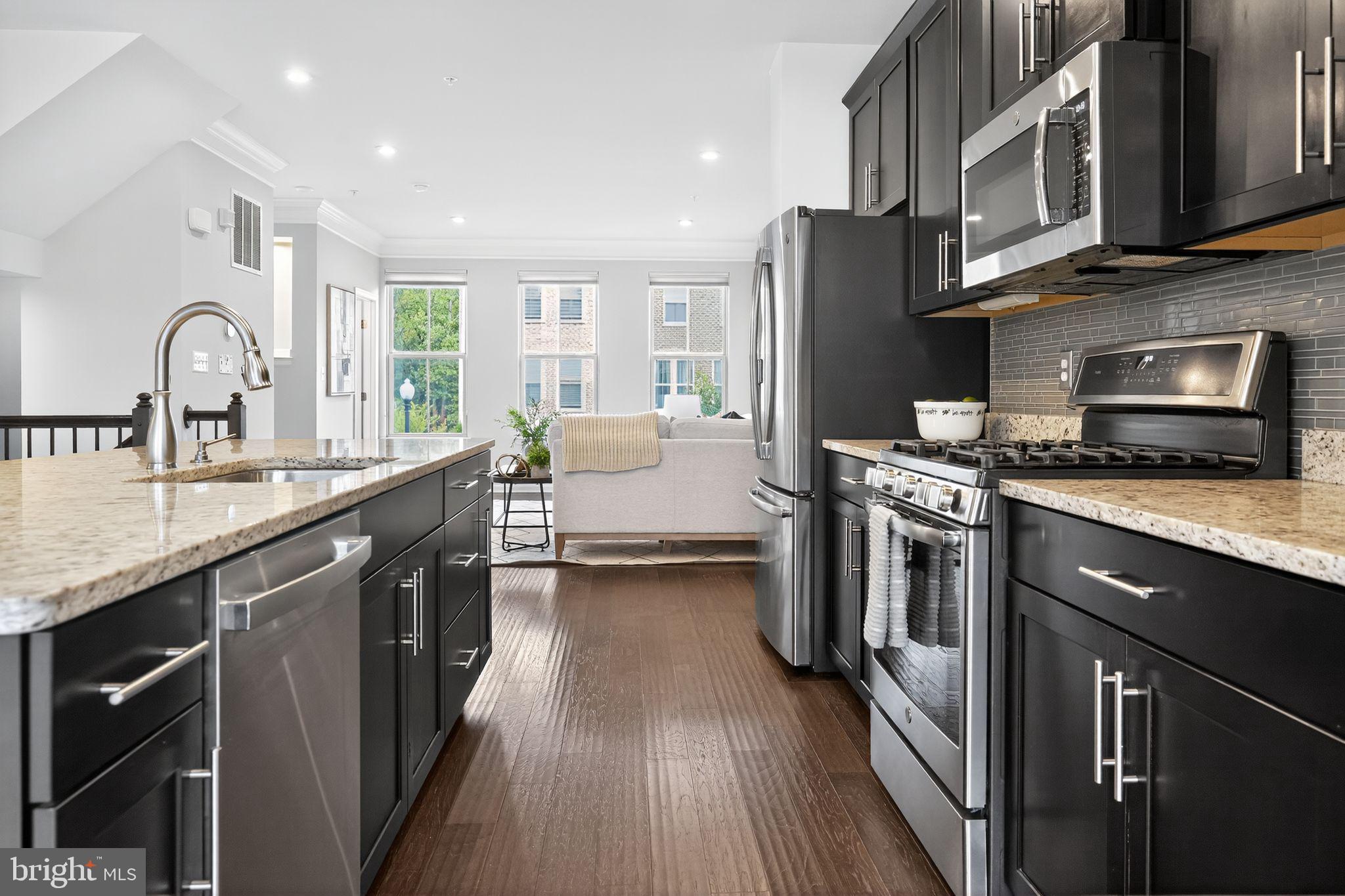 3637 Jamison Street Northeast Washington, DC 20018 - Photo 12 of 44 a kitchen with stainless steel appliances granite countertop a stove refrigerator sink and cabinets
