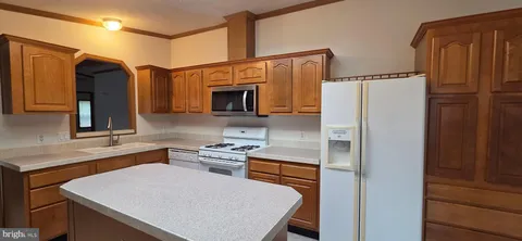 a kitchen with stainless steel appliances a refrigerator sink and microwave