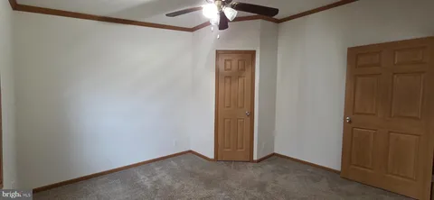 a view of an empty room with a chandelier fan