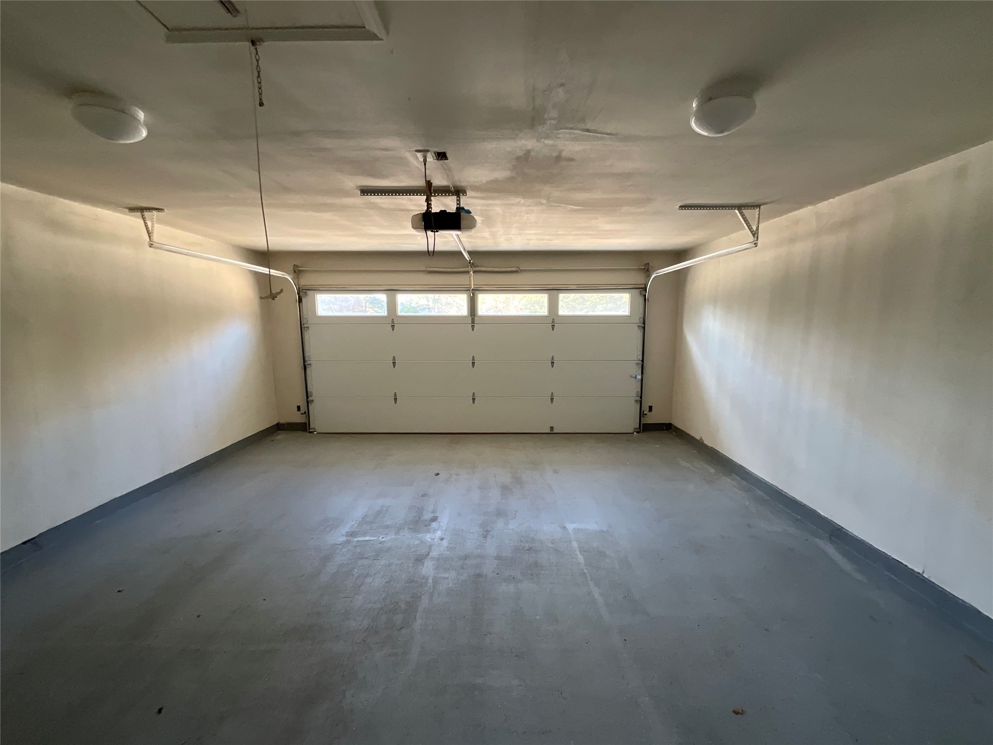 239 Old Firetower Road Bastrop, TX 78602 - Photo 27 of 39 Garage featuring baseboards and a garage door opener