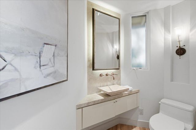 a bathroom with a sink a toilet and mirror