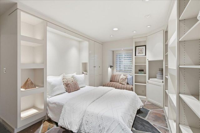 a bedroom with a large bed and a chandelier