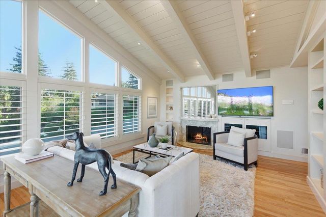 a living room with fireplace furniture and a large window
