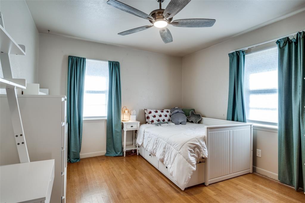 2602 Ridgecrest Drive Garland, TX 75041 - Photo 15 of 24 a bedroom with a large bed and a chandelier