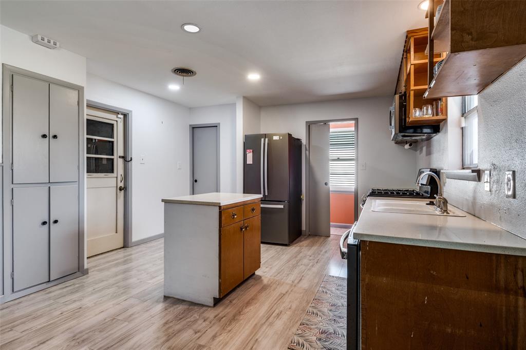 2602 Ridgecrest Drive Garland, TX 75041 - Photo 8 of 24 a kitchen with stainless steel appliances a refrigerator sink and wooden floor
