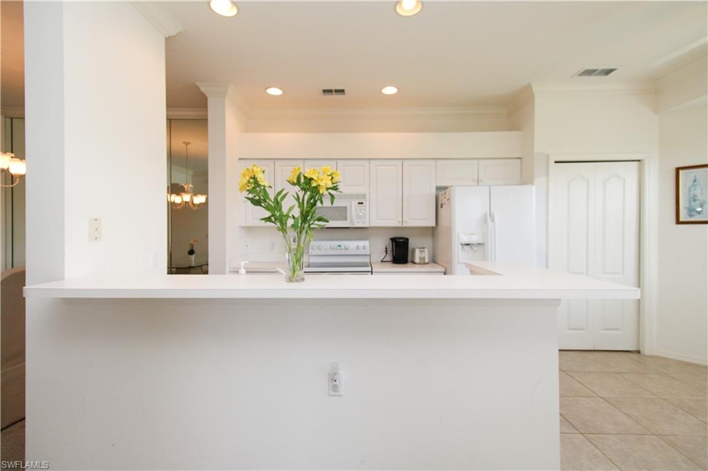 3820 Sawgrass Way, Unit 3046 Naples, FL 34112 - Photo 15 of 50 a kitchen with kitchen island a sink appliances and cabinets