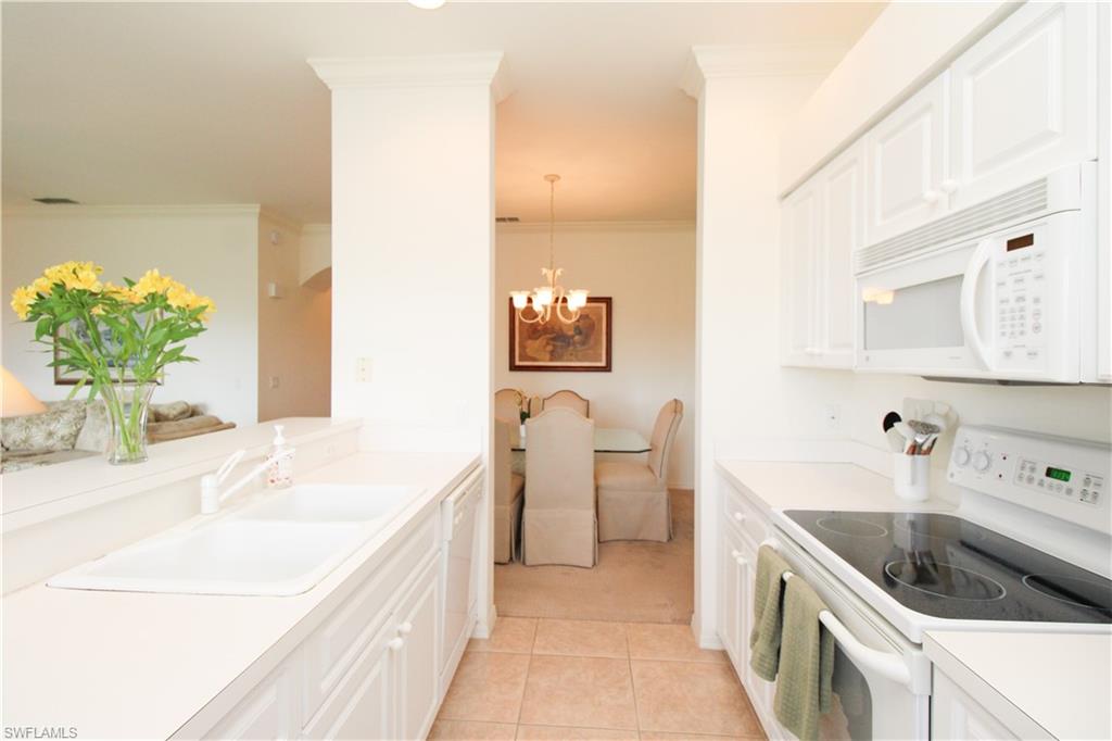 3820 Sawgrass Way, Unit 3046 Naples, FL 34112 - Photo 18 of 50 a kitchen with a sink and a refrigerator