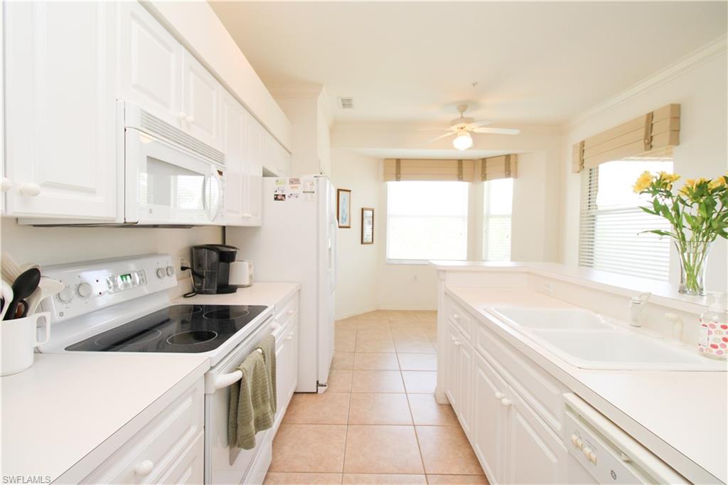 3820 Sawgrass Way, Unit 3046 Naples, FL 34112 - Photo 23 of 50 a kitchen with a sink a stove a refrigerator and a window