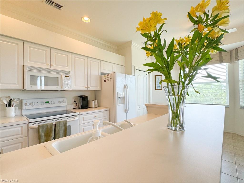 3820 Sawgrass Way, Unit 3046 Naples, FL 34112 - Photo 29 of 50 a kitchen with stainless steel appliances a white refrigerator a sink and a stove