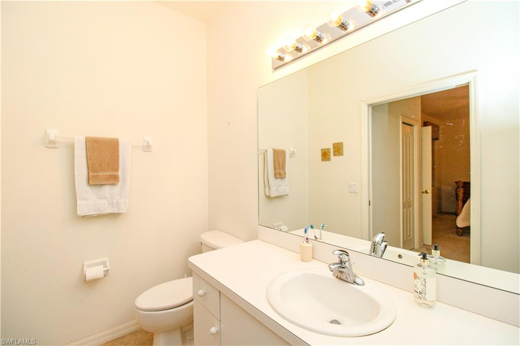 3820 Sawgrass Way, Unit 3046 Naples, FL 34112 - Photo 5 of 50 a bathroom with a sink mirror vanity and toilet