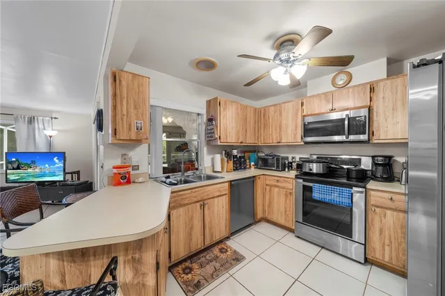 a kitchen with a chandelier a sink and appliances