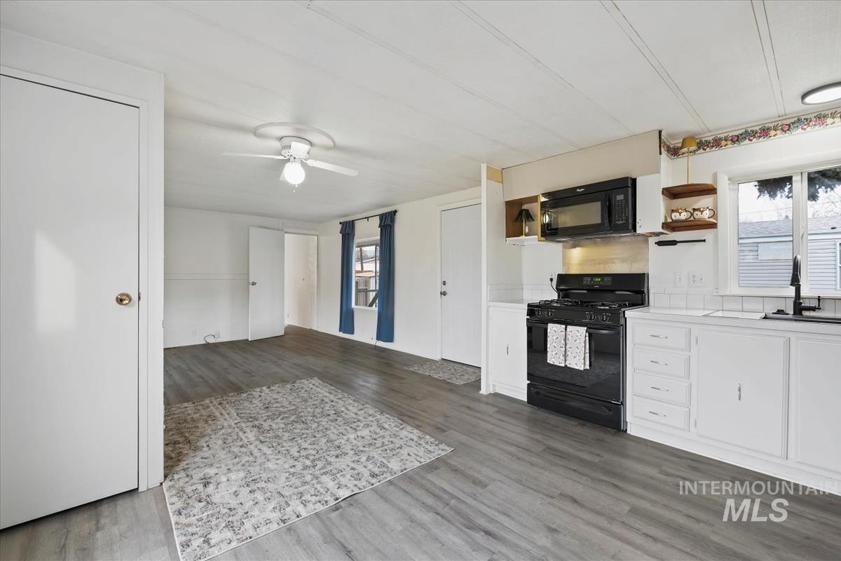 10167 Maymie Road Boise, ID 83714 - Photo 14 of 31 Kitchen with black appliances, open shelves, white cabinets, dark wood-style flooring, and ceiling fan
