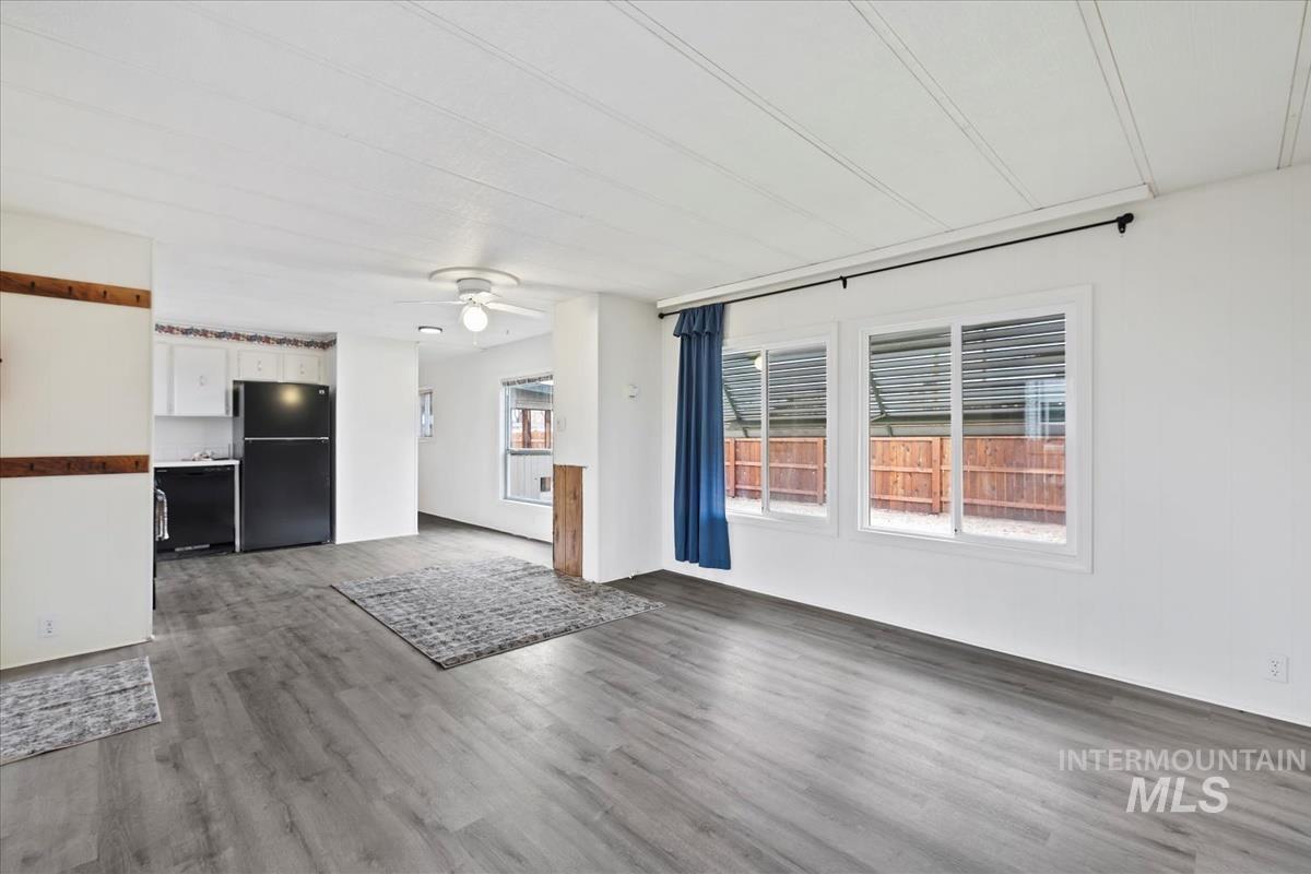 10167 Maymie Road Boise, ID 83714 - Photo 3 of 31 Unfurnished living room featuring wood finished floors and a ceiling fan