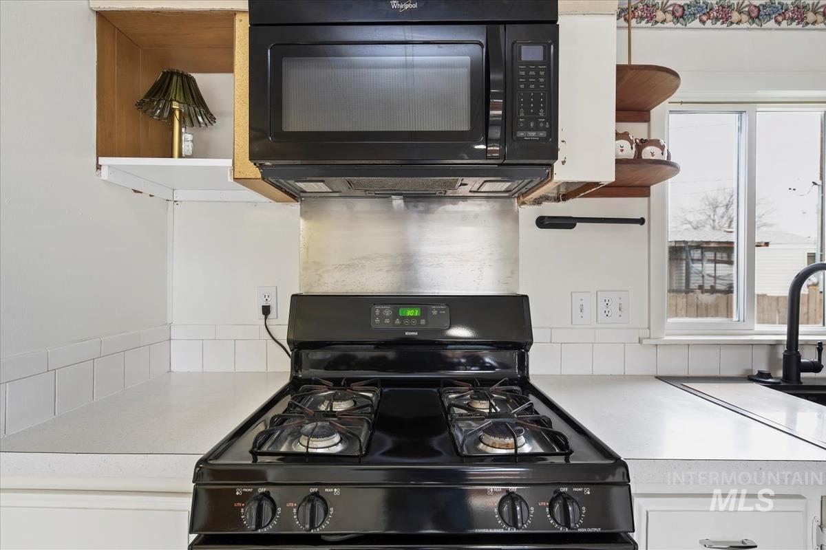10167 Maymie Road Boise, ID 83714 - Photo 10 of 31 Kitchen with black appliances, open shelves, and light countertops