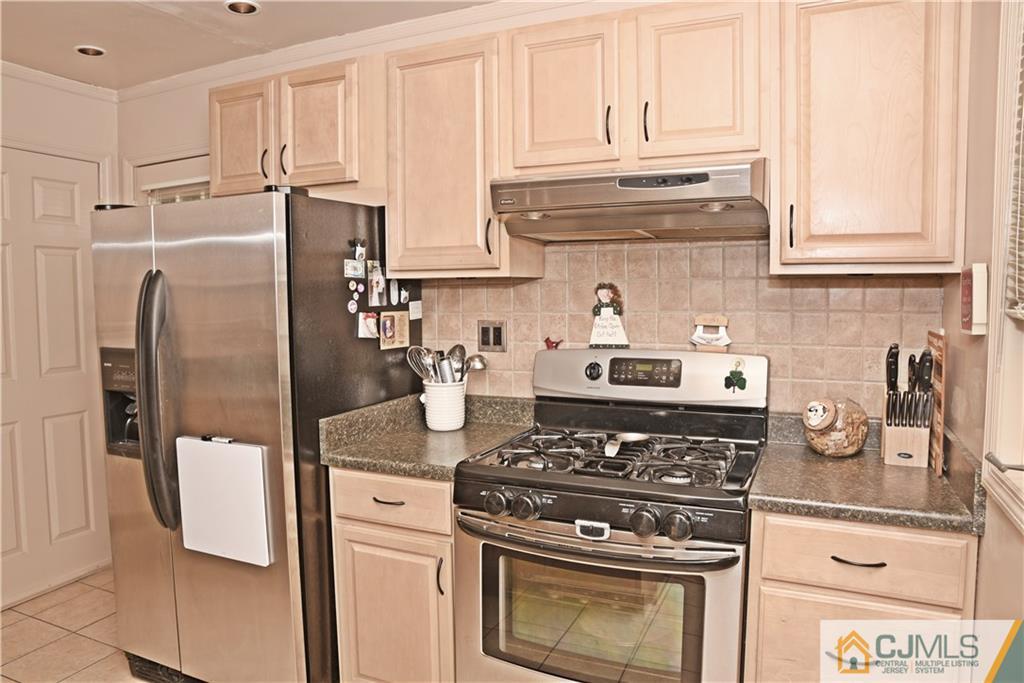 58 Princeton Road Old Bridge, NJ 08859 - Photo 7 of 24 a kitchen with stainless steel appliances granite countertop a stove a refrigerator and a white cabinets
