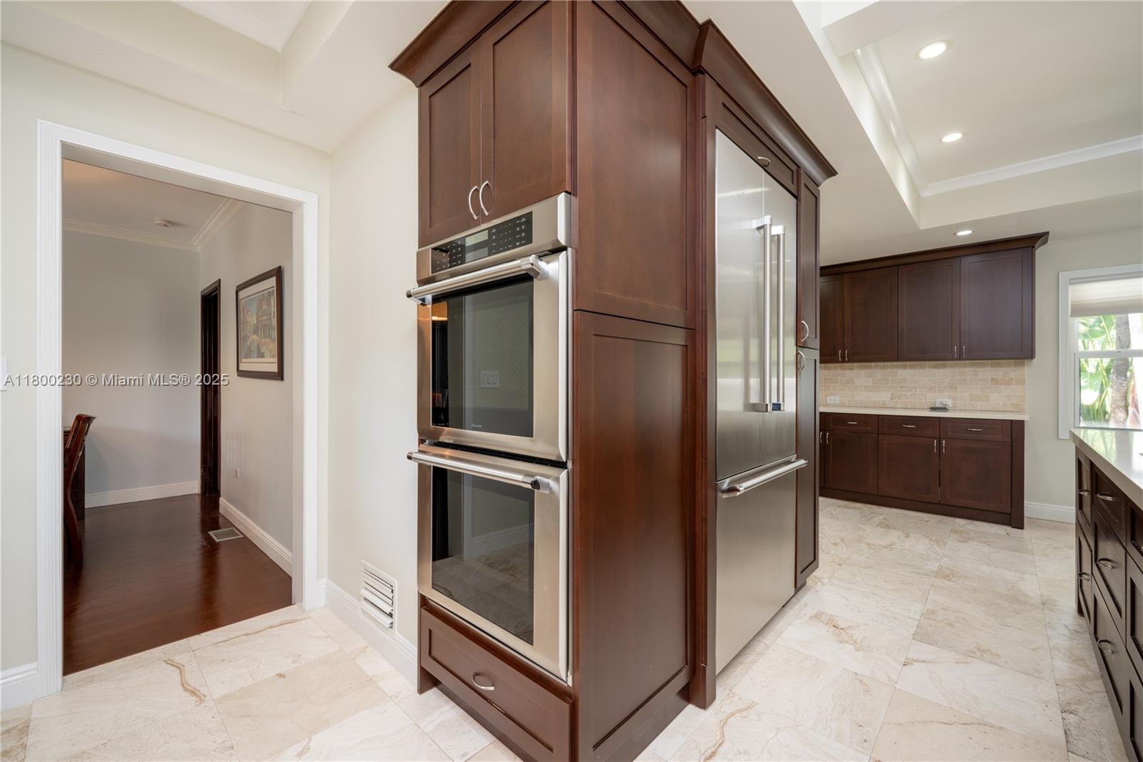 2855 Southwest 17th Avenue Miami, FL 33133 - Photo 35 of 84 a kitchen with stainless steel appliances kitchen island granite countertop a refrigerator and a sink