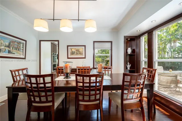 a dining room with furniture water view and a floor to ceiling window