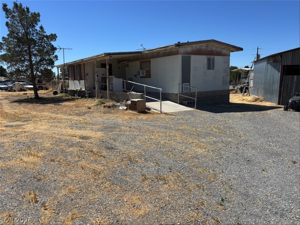 1301 East Manse Road Pahrump, NV 89048 - Photo 6 of 14 A wide gravel driveway leads to this single-story structure with a covered entrance ramp.