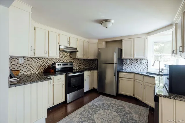 a kitchen with stainless steel appliances granite countertop a stove a sink and a refrigerator