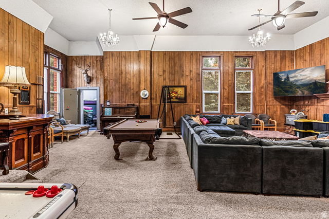 21 North Main Street Kingston, UT 84743 - Photo 35 of 107 Living room with a ceiling fan, hanging lights, a textured ceiling, carpet floors, and wooden walls