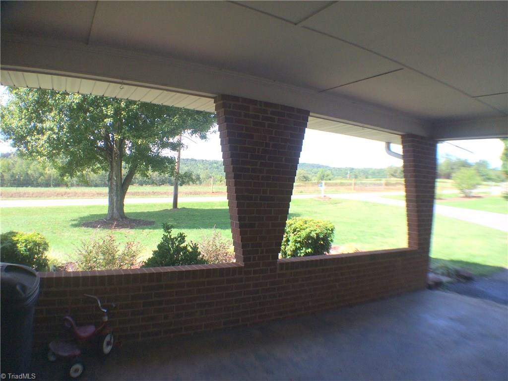 5241 Rena Road Hamptonville, NC 27020 - Photo 18 of 22 Double Attached Finished Carport with Brick Knee Wall and Columns, Cement floor, and Finished Ceiling. Driveway is paved. Nice Rural and Mountain Views from the property.