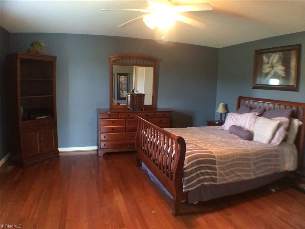 5241 Rena Road Hamptonville, NC 27020 - Photo 5 of 22 Owners Suite with Hardwood Flooring, Ceiling Fan, and Walk-in Closet