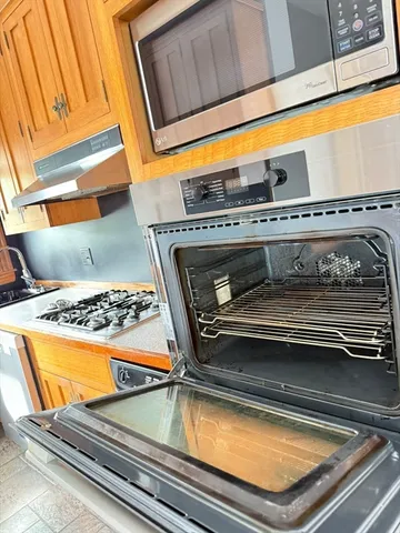 a kitchen with stainless steel appliances granite countertop a stove a sink and a refrigerator