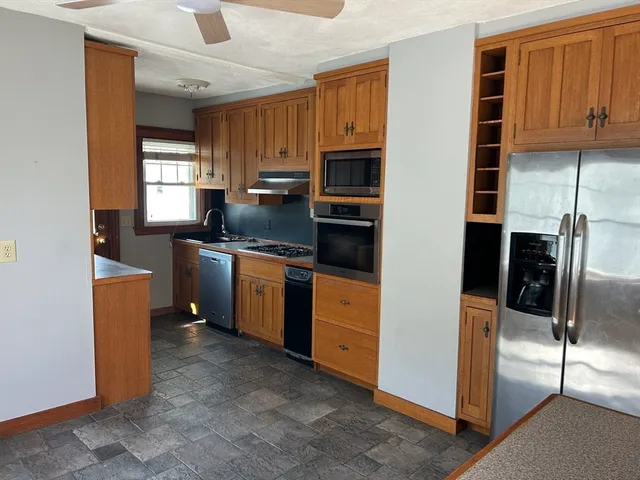 a kitchen with stainless steel appliances granite countertop a refrigerator a stove top oven a sink and dishwasher