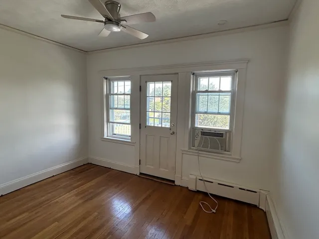 a view of a livingroom with a window and wooden floor