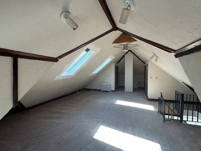 a view of an empty room with stairs and a window
