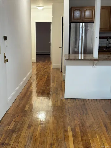 a view of a refrigerator in kitchen and wooden floor