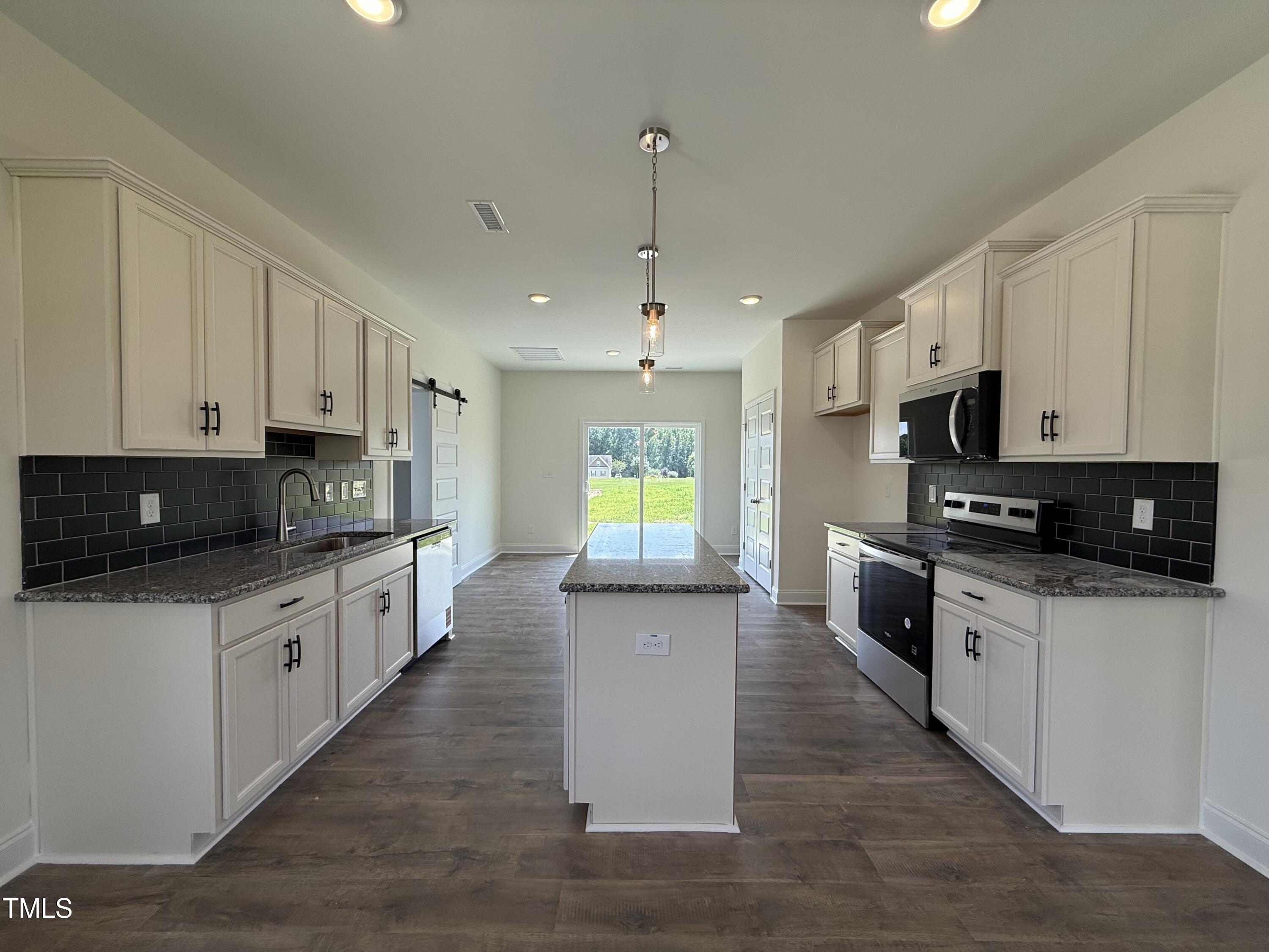 432 Springtooth Drive Zebulon, NC 27597 - Photo 2 of 15 a large kitchen with stainless steel appliances granite countertop a stove a sink and a microwave