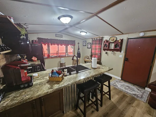 a kitchen with granite countertop a sink stove and cabinets
